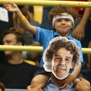 17.fev.2013- Nos ombros do pai mascarado de Guga, jovem torcedor acompanha as finais do Aberto do Brasil, no ginásio do Ibirapuera em São Paulo - Wagner Carmo/inovafoto