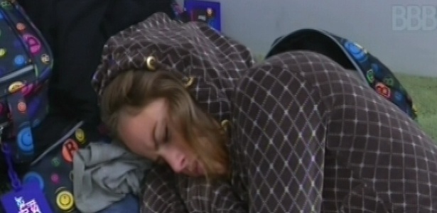 18.fev.2013 - Após toque de despertar, Natália dorme no chão da sala enquanto espera outros brothers irem no banheiro