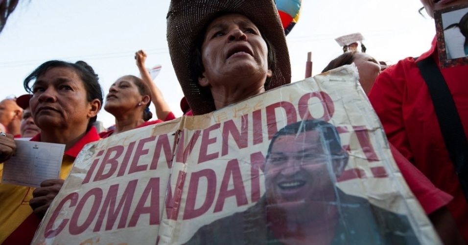 18.fev.2013 - Venezuelana exibe cartaz de boas vindas ao presidente Hugo Chávez, que retornou ao país nesta segunda-feira (18), mais de dois meses após viajar para Havana (Cuba) para se submeter a um tratamento contra um câncer