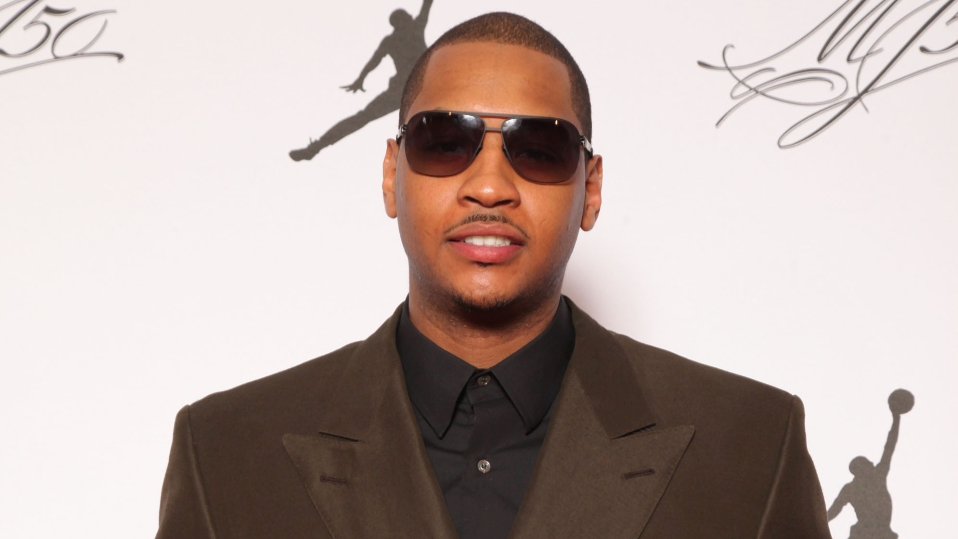 18.fev.2013- Carmelo Anthony escolheu uma camisa preta com terno marrom e calça estampada para a festa de Michael Jordan - Omar Vega/AP Images