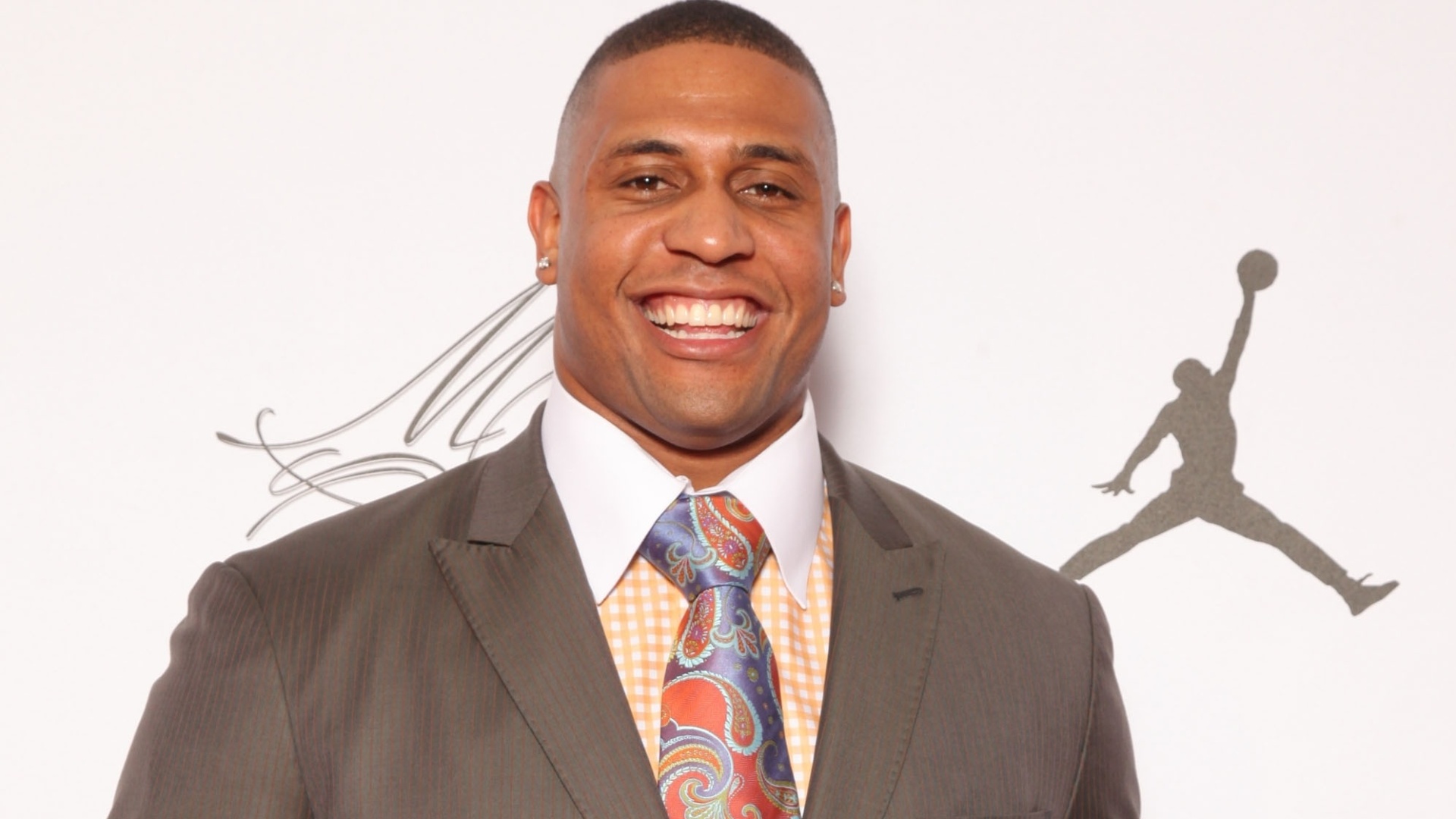 18.fev.2013- Jogador de futebol americano LaMarr Woodley, do Pittsburgh Steelers, combinou uma camisa quadrculada amarela com gravata de estampa de lenço para a festa - Omar Vega/AP Images