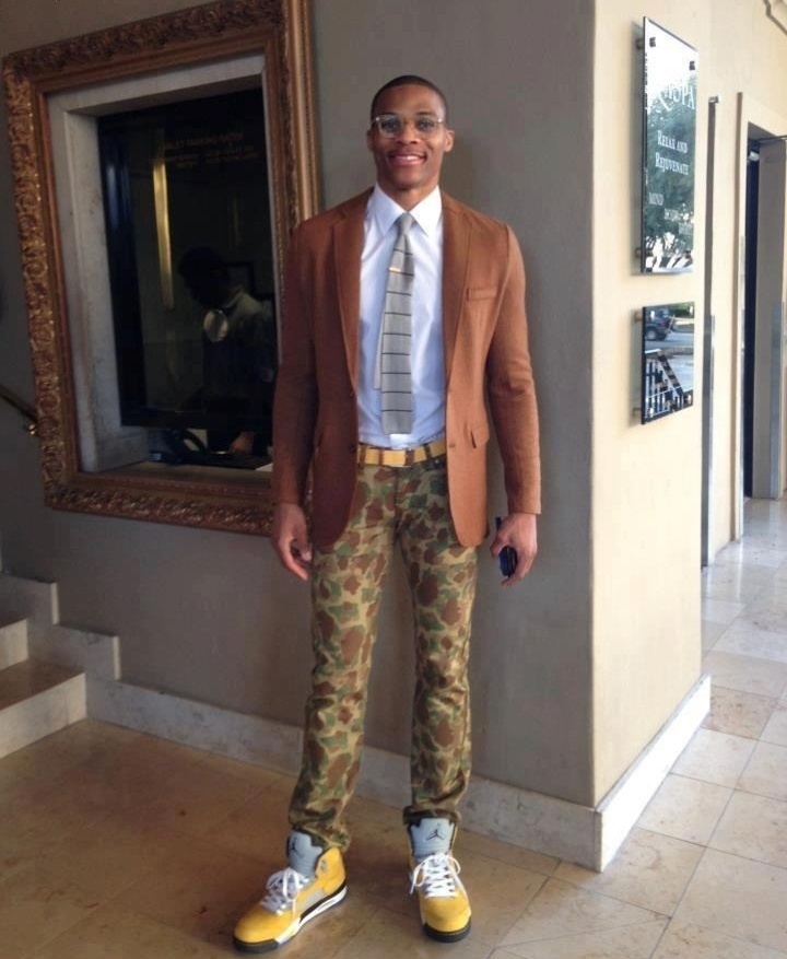 18.fev.2013- Russell Westbrook escolheu uma calça militar, combinada com um terno marrom, gravata cinza e cinto e tênis amarelo para ir à festa de Michael Jordan - Reprodução