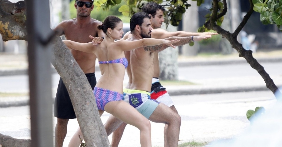 19.fev.2013 - Os atores Milena Toscano e Juliano Cazarré fazem aquecimento antes de entrarem no mar para praticar stand-up paddle