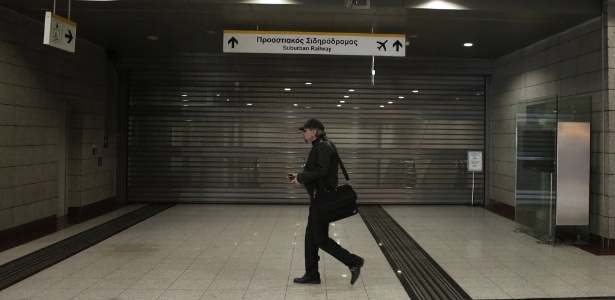 Homem passa em frente a estação de metrô fechada em Atenas (Grécia). O país enfrenta uma paralisação geral de 24 horas contra cortes de salários e impostos elevados - John Kolesidis/Reuters