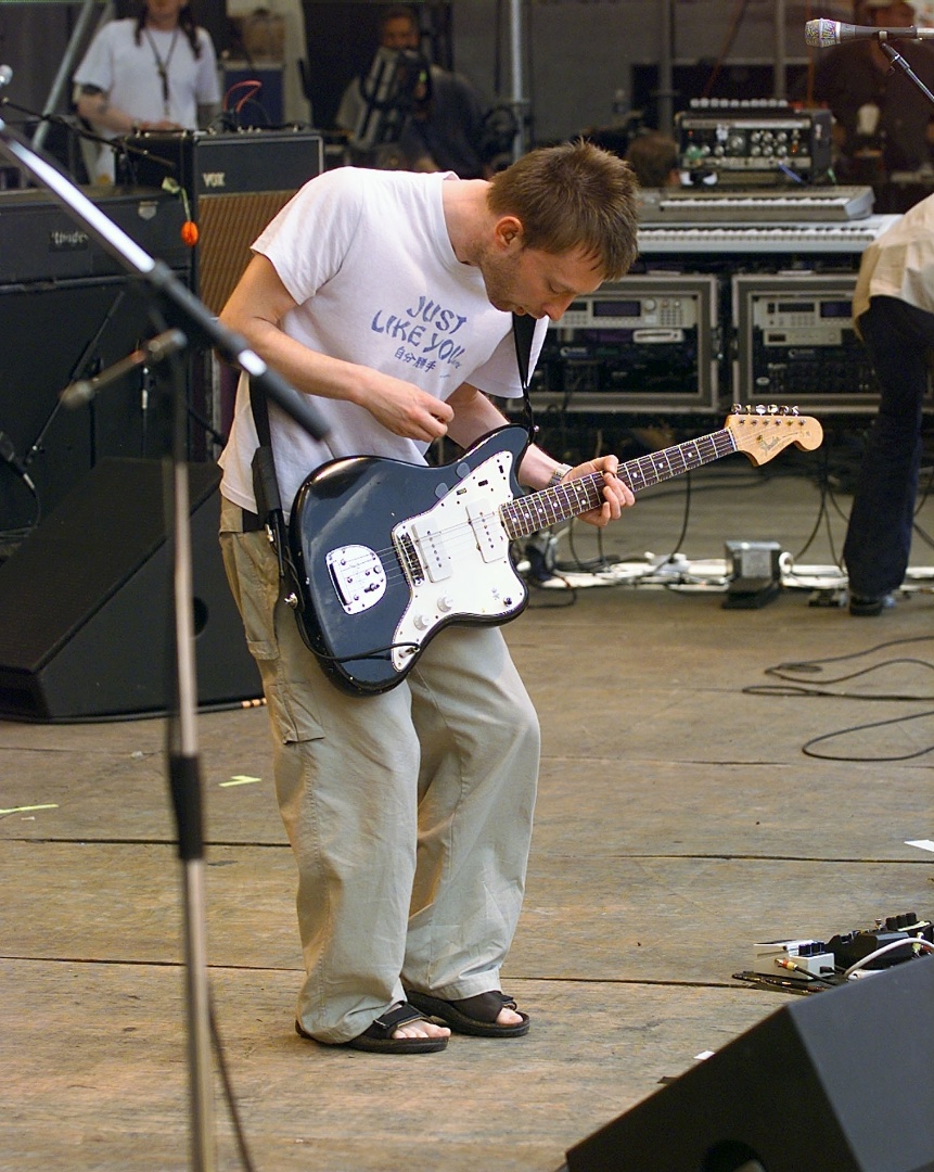 1998 - Vestido de chinelo, moletom e camiseta, com o cabelo curto, Thom Yorke se apresenta no Tibetan Freedom Music Festival. Na época, a banda colhia os bons frutos de "OK Computer", um dos álbuns da banda mais aclamados pelo público e pela crítica - Frank Micelotta/Getty Images