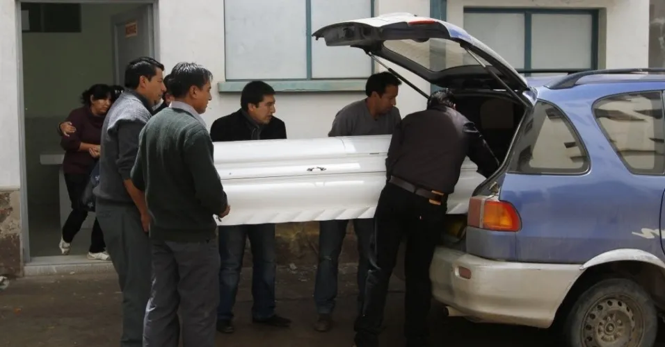 21.fev.2013 - Caixão com o corpo do jovem Kevin Beltran Estrada, de 14 anos, é colocado dentro de carro em Oruro - AP Photo/Juan Karita