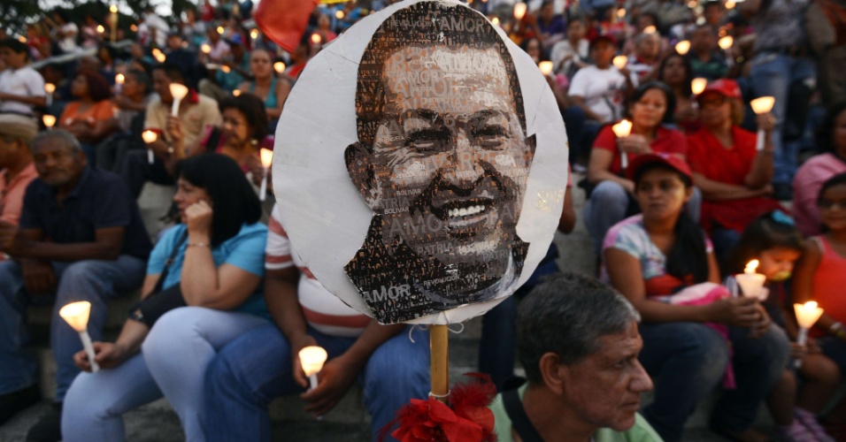 22.fev.2013 - Foto do presidente venezuelano, Hugo Chávez, ganha destaque em meio a multidão que compareceu à vigília realizada no centro de Caracas, na Venezuela, em homenagem ao político que se recupera de uma cirurgia de câncer