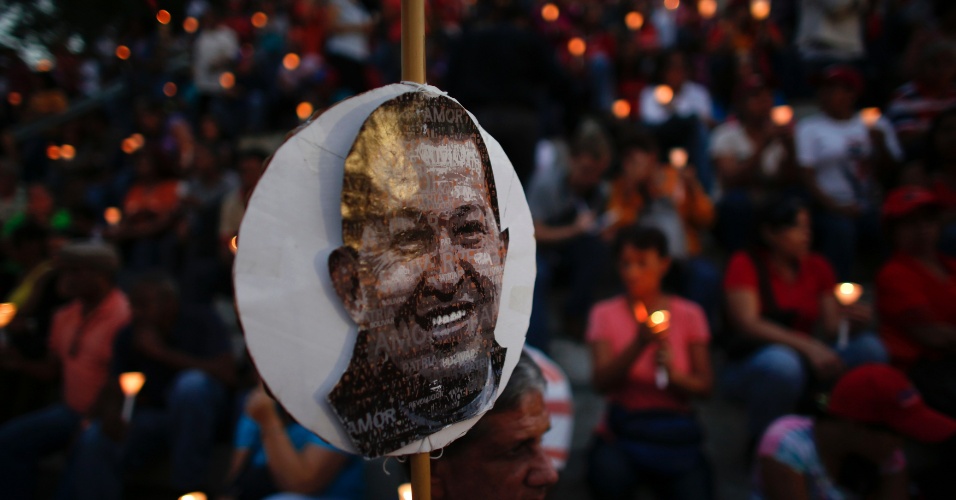 22.fev.2013 - Foto do presidente venezuelano, Hugo Chávez, ganha destaque em meio a multidão que compareceu à vigília realizada no centro de Caracas, na Venezuela, em homenagem ao político que se recupera de uma cirurgia de câncer