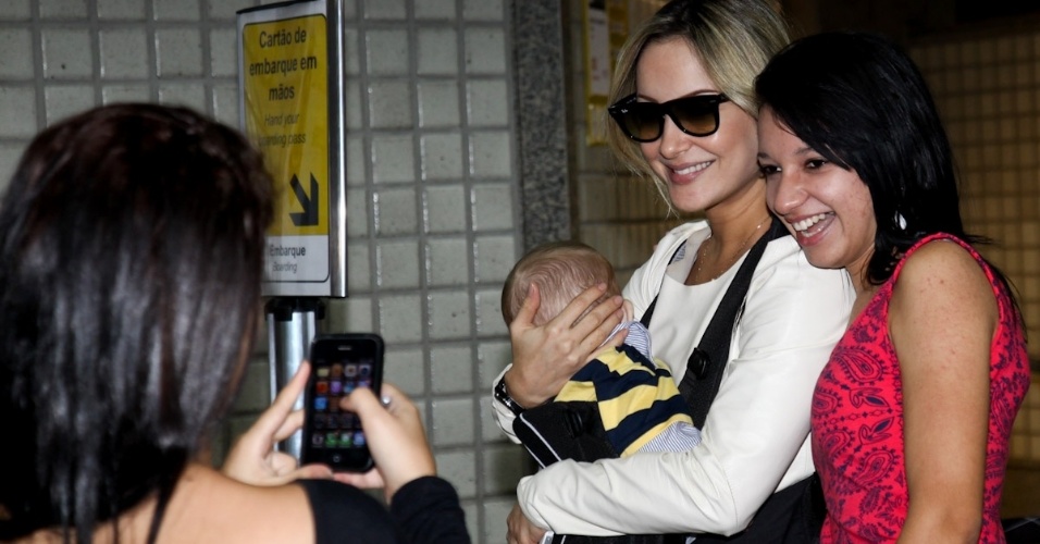 23.fev.2013 - Com o filho Rafael no colo, Claudia Leitte tira foto com fã no aeroporto de Guarulhos