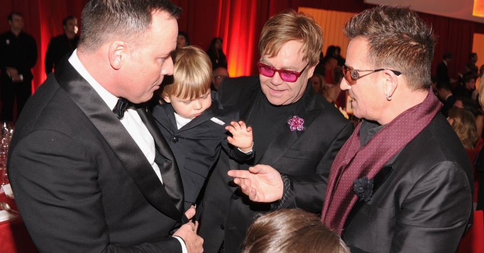 24.fev.2013 - Zachary, o filho de dois anos de Elton John e David Furnish, cumprimenta o cantor Bono na festa de gala prmovida por Elton em Los Angeles