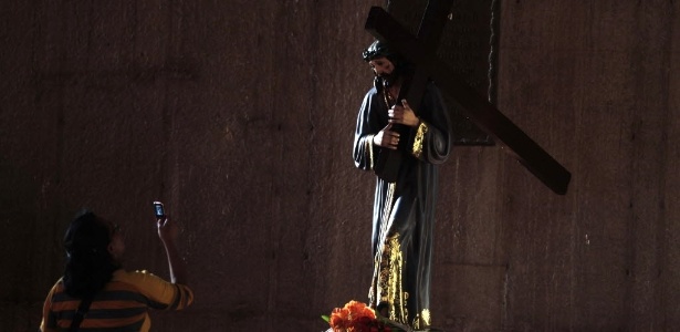 25.fev.2013 - Mulher tira foto com seu celular de estátua de Jesus Cristo na catedral de Manágua (Nicarágua) - Oswaldo Rivas/Reuters