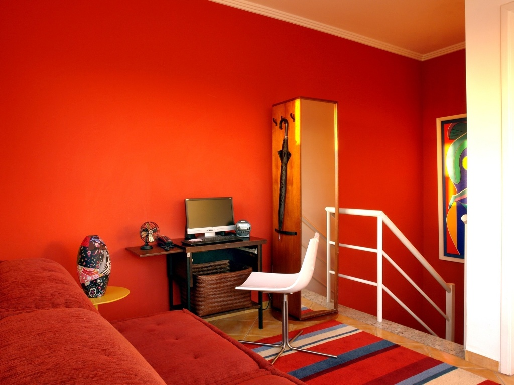 A partir do pedido do cliente, as tonalidades do vermelho foram largamente exploradas pela arquiteta Cristiane Schiavoni para a decoração do ambiente. "O cliente se sente em casa, aconchegado", conta a profissional - Divulgação