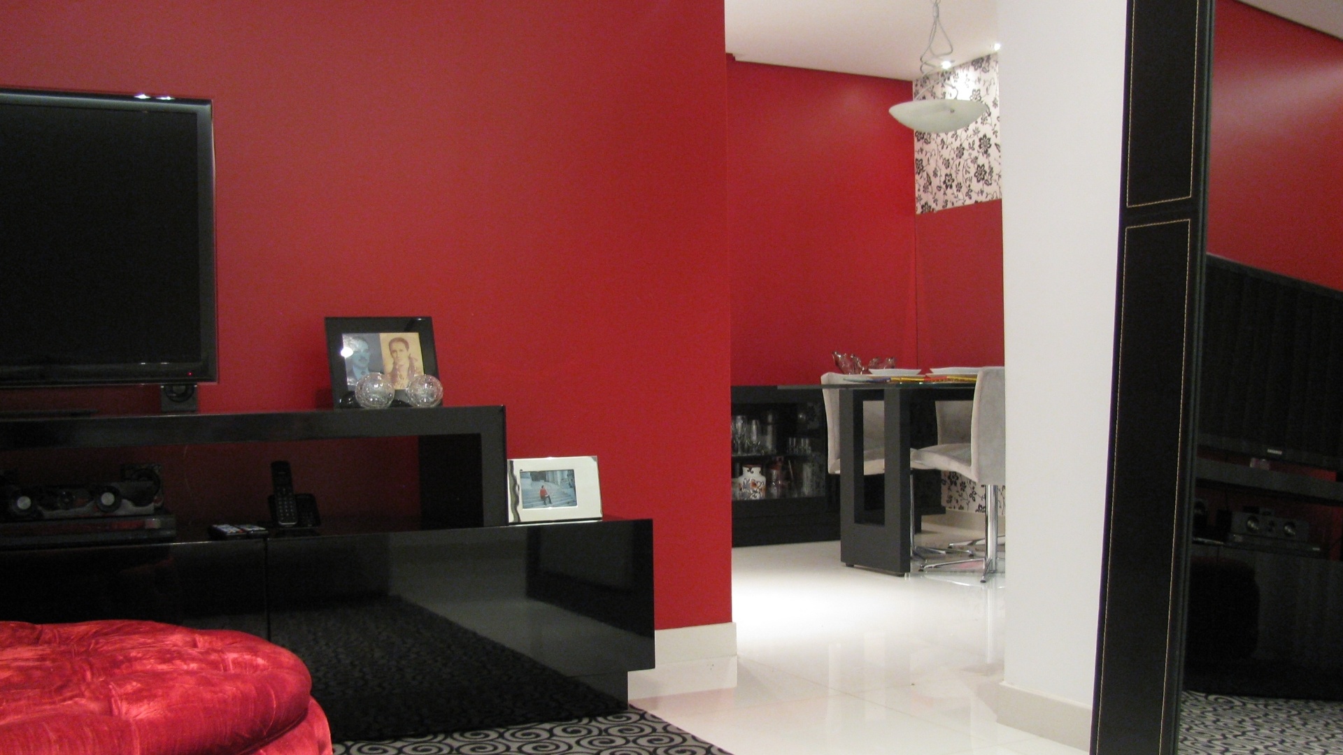 No projeto das designers de interiores Fabiana Visacro e Laura Santos, da VS Design, o uso da mesma cor (o vermelho) nas paredes das salas de estar e jantar funcionam como um elemento integrador para os dois espaços - Alexandre Lima/Divulgação