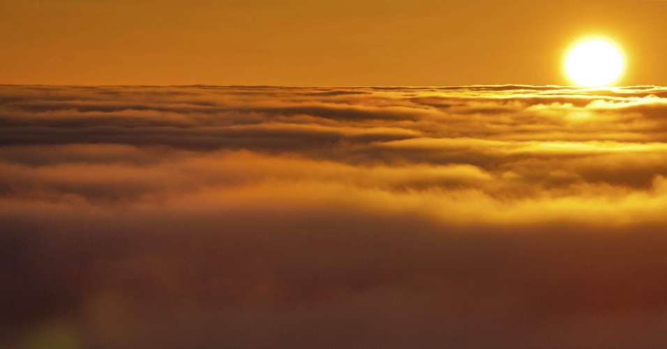 01.mar.2013 - Vista de um pôr do sol com a neblina que cobre as montanhas em Neudorf, na Alemanha