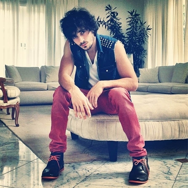 1.mar.2013 - Sentado em sofá, Fiuk posa com colete jeans e calça vermelha