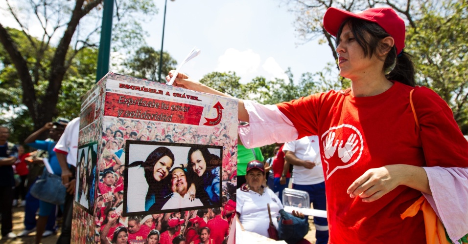 5.mar.2013 - Mulher envia mensagem de apoio ao presidente venezuelano, Hugo Chávez, e família nesta terça-feira (5), em urna instalada em frente ao Hospital Militar de Caracas onde o presidente está internado