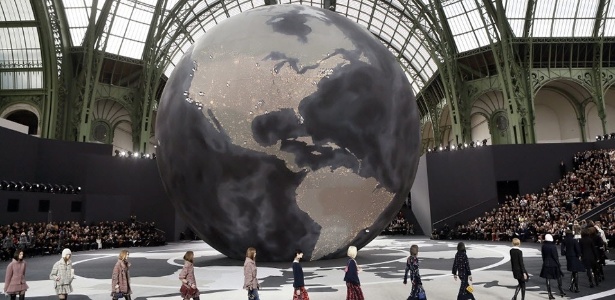Ao centro da passarela da Chanel, um globo representa a expansão da grife pelo mundo. São, ao todo, 100 pontos de venda próprios - Patrick Kovarik/AFP