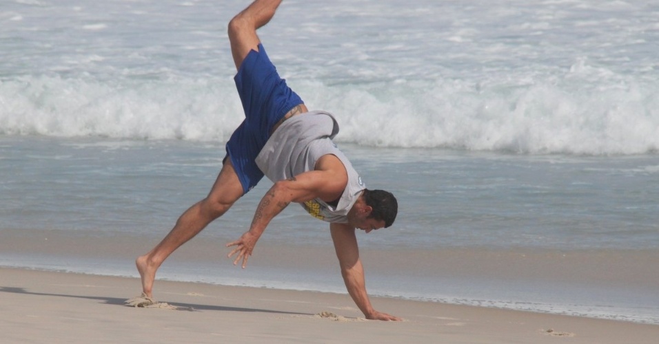 6.mar.2013 - O ex-BBB Kléber Bambam praticou capoeira na praia da Barra da Tijuca, zona oeste do Rio