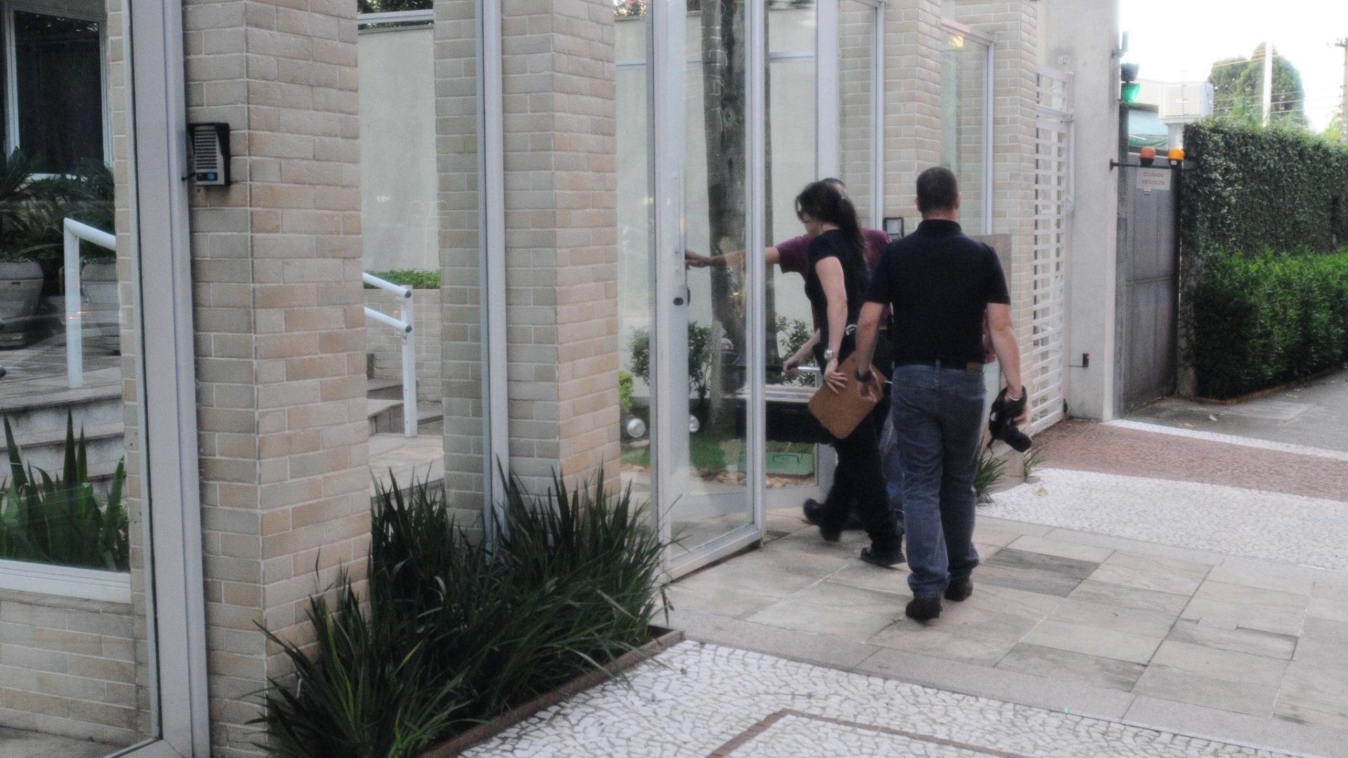 6.mar.2013 - Policiais entram no prédio de Chorão, onde o cantor foi encotrado morto nesta manhã no bairro de Pinheiros, em São Paulo - Adriano Lima/Brazil Photo Press