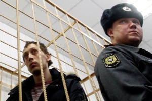 Pavel Dmitrichenko (à esq.), bailarino acusado de atacar com ácido o diretor artístico do balé Bolshoi assiste, da cela do réu, a audiência sobre o caso, em corte de Moscou - Maxim Shemetov/Reuters
