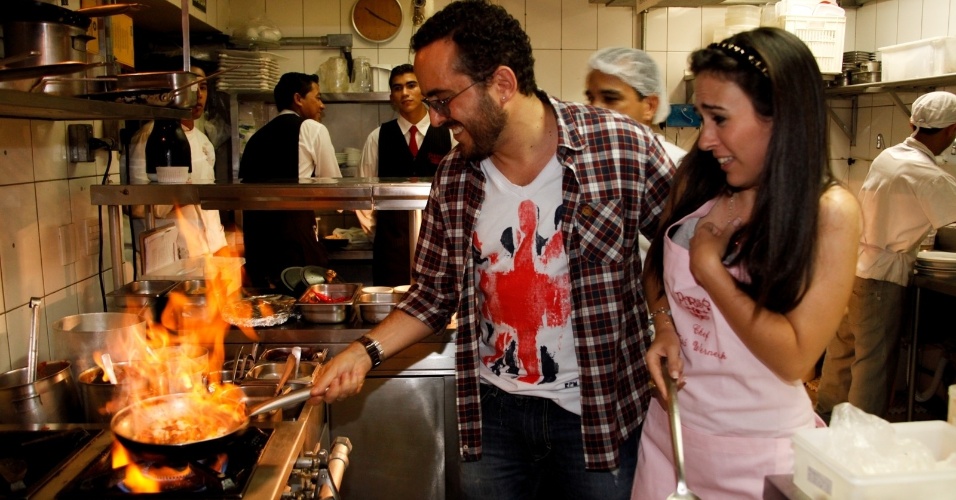 7.mar.2013 - A atriz Tatá Werneck, que está no elenco da próxima novela das nove da Globo, ajuda a preparar prato que terá seu nome junto do proprietário do estabelecimento, Isaac Azar