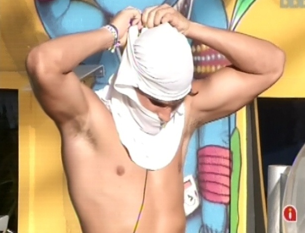 8.mar.2013 - André cobre o rosto com camiseta para se proteger do sol durante a prova