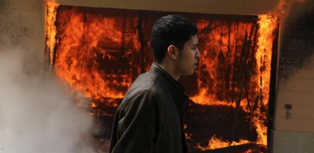 Homem passa em frente a uma delegacia que foi incendiada após o anúncio das condenações - AP Photo/Ahmed Gomaa