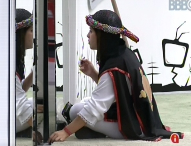 10.mar.2013 - Andressa, vestida de guardiã por causa do castigo do monstro, se maquia no espelho antes de voltar a dormir