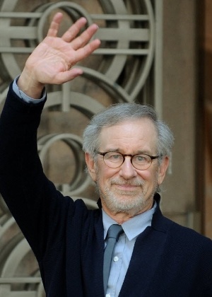 Steven Spielberg  acena para fotógrafo ao deixar o escritório de Anil Ambani em Mumbai, na Índia - Punit Paranjpe/AFP