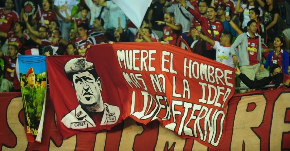 12.mar.2013 - Torcedores do Caracas (VEN) homenageiam Hugo Chávez, ex-presidente do país, que morreu na semana passada - AFP PHOTO/RONALDO SCHEMIDT