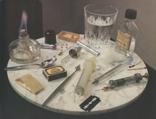 Obra do artista e cineasta francês Daniel Pommereulle, falecido em 2003. Sua exposição “Objetos de tentação” nos anos 60, com mesas cheias de drogas e objetos para consumi-las provocou grande escândalo na época. Na época, ainda era possível expor drogras ilegais. Ao término da exposição, os visitantes tinham levado tudo embora - Divulgação