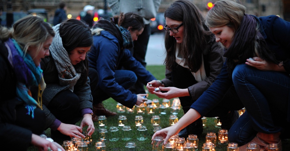 15.mar.2013 - Mulheres acendem velas no centro de Londres, no Reino Unido, em ação mundial da ONG Save the Children na noite desta quinta-feira (14).  A vígilia, que ocorreu em 20 cidades diferentes, lembra os dois anos de levante popular contra o regime de Bashar Al-Assad