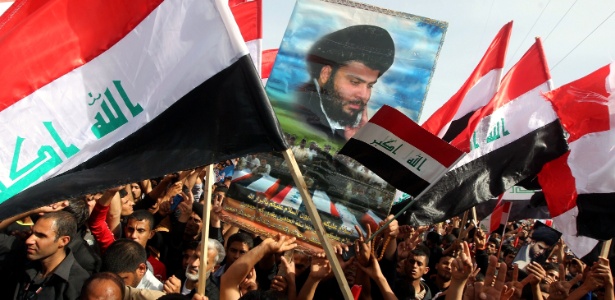 Seguidores do clérigo iraquiano xiita Moqtada al-Sadr agitam bandeiras nacionais em Bagdá (Iraque) por ocasião dos dez anos da invasão norte-americana ao país - Ahmad Al-Rubaye/AFP - 16.mar.2013 