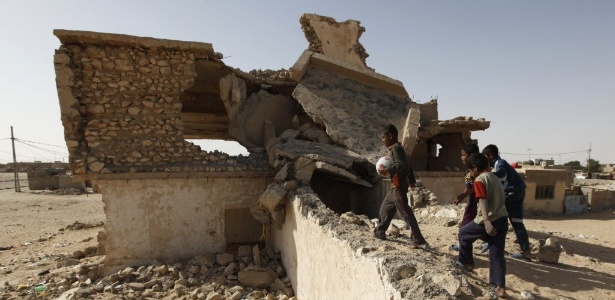 Crianças circulam perto de ruínas de prédio supostamente destruído em 2003 pelas tropas americanas  - Mohammed Ameen/Reuters
