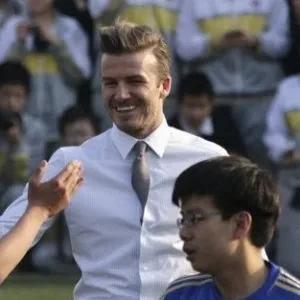 20.mar.2013 - David Beckham não perdeu a elegância no visual para jogar bola com crianças na China - Petar Kujundzic/Reuters