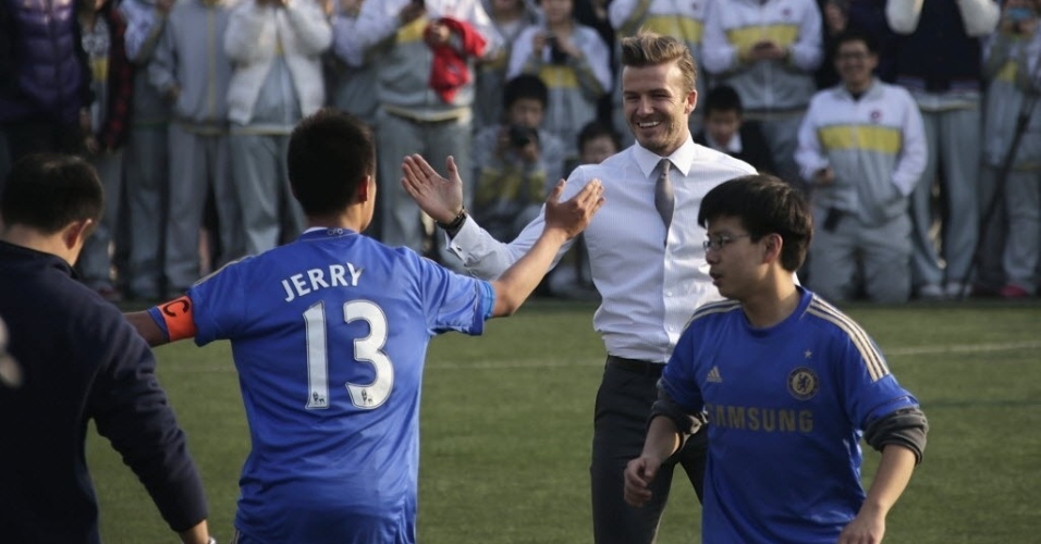 20.mar.2013 - David Beckham não perdeu a elegância no visual para jogar bola com crianças na China - Petar Kujundzic/Reuters