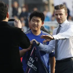 20.mar.2013 - David Beckham posa ao lado de estudante na China - How Hwee Young/EFE