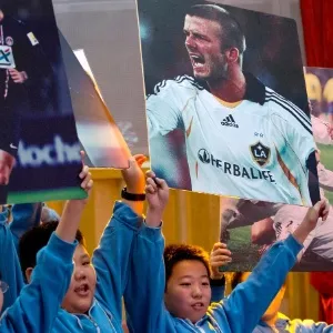 20.mar.2013 - Estudantes chineses exibem cartazes de David Beckham, que visitou a China - Alexander F. Yuan/AP