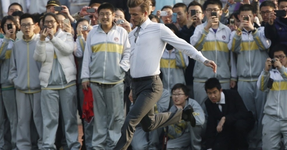 20.mar.2013 - Estudantes chineses tietam David Beckham em Pequim - How Hwee Young/EFE