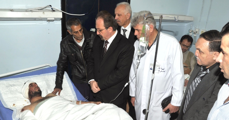 22.mar.2013 - Em imagem divulgada nesta sexta-feira, o ministro da Saúde da Síria, Saad Abdel Salam al-Nayef (no centro, de óculos), visita feridos em hospital de Damasco, após atentado suicida contra mesquita que deixou ao menos 40 pessoas mortas, incluindo um alto clérigo muçulmano pró-governo, e mais de 80 feridos