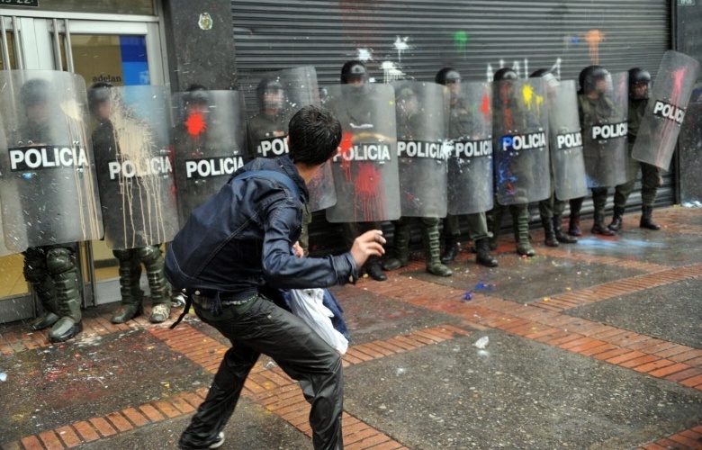 22.mar.2013 - Estudante joga bombas de tinta em policiais durante protesto por melhorias na educação em Bogotá, capital da Colômbia