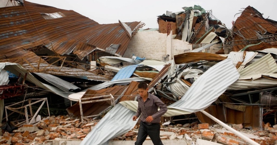 22.mar.2013 - Homem caminha por fábrica destruída por tempestade e fortes ventos, na região de Dongguan, na província chinesa de Guangdong