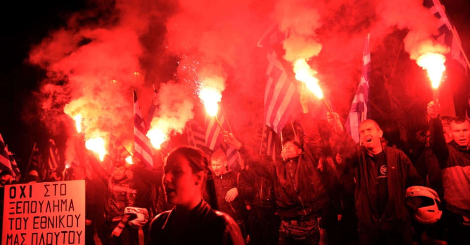 22.mar.2013 - Membros do partido ultranacionalista Amanhecer Dourado cantam o hino nacional grego em frente da embaixada alemã em Atenas, nesta sexta-feira. Pelo menos 1 mil nacionalistas protestam contra os planos de austeridade da União Europeia para a ilha de Chipre