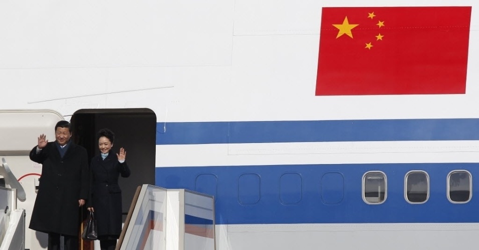 22.mar.2013 - O presidente chinês, Xi Jinping, e a primeira-dama, Peng Liyuan, acenam ao desembarcarem no aeroporto de Moscou (Rússia). É a primeira viagem ao exterior de Xi Jinping como líder do país asiático. O roteiro dele também inclui escalas na Tanzânia, África do Sul e República do Congo