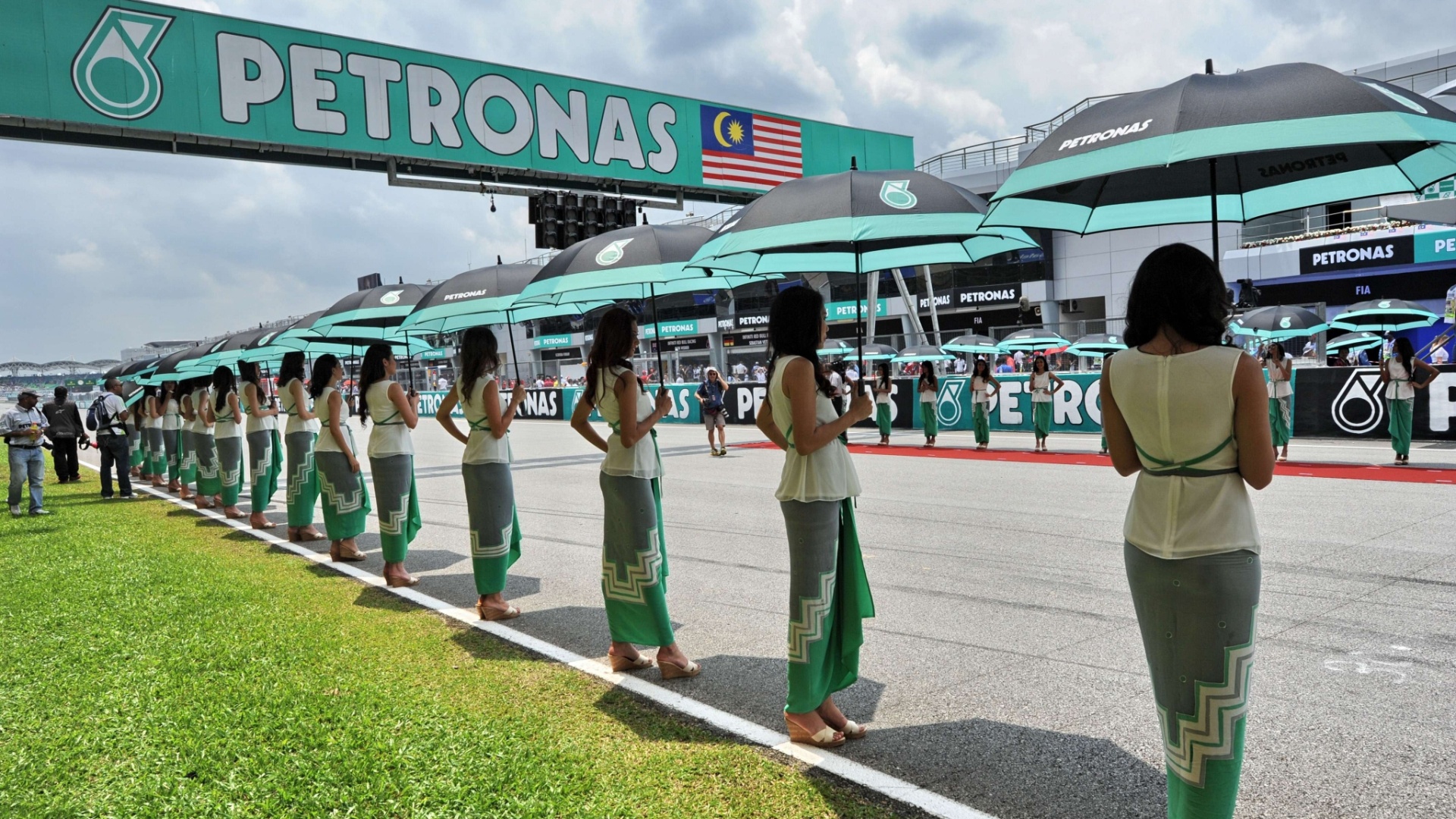 24.mar.2013 - Belas grid girls fazem pose na reta dos boxes do circuito de Sepang - Roslan Rahman/AFP