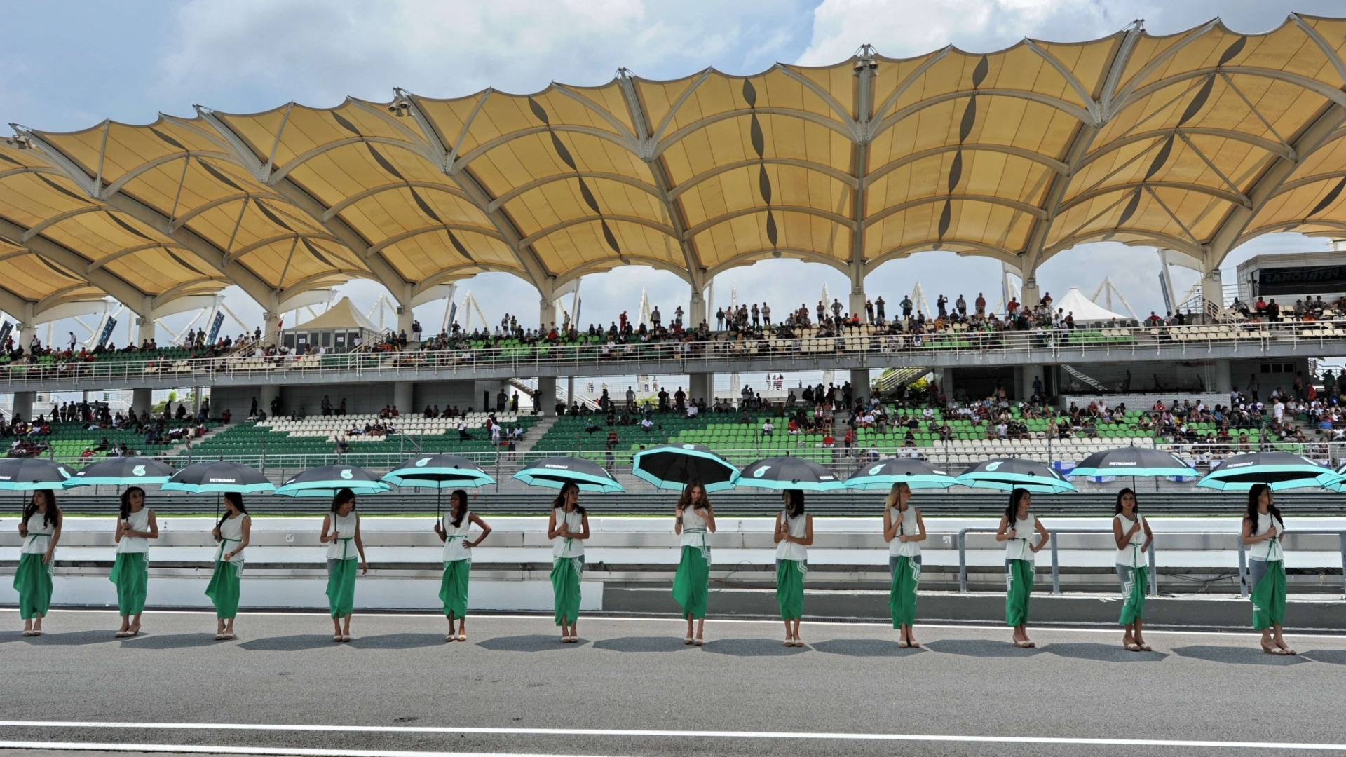 24.mar.2013 - Belas grid girls fazem pose na reta dos boxes do circuito de Sepang - Roslan Rahman/AFP