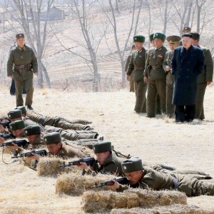  O líder norte-coreano Kim Jong-Un (em pé, ao centro) acompanha treino do Exército em local não revelado pela KCNA (agência oficial do país), que divulgou a imagem
