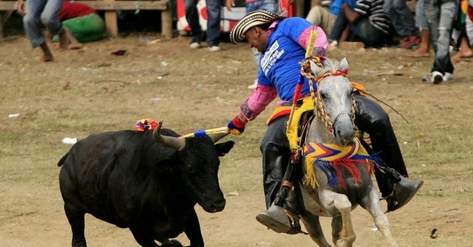 25.mar.2013 - Homem participa da "corraleja" (curral, em português) celebrada em Arjona, um pequeno povoado próximo à Cartagena, no norte da Colômbia. A corraleja é uma festa popular da costa caribenha do país. Durante a festividade, o público luta contra touros sem, no entando, matar os animais - Ricardo Maldonado Rozo/Efe