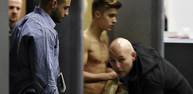 Seguranças tentam bloquear a visão do cantor Justin Bieber enquanto ele atravessa o aeroporto Wladyslaw Reymont em Lodz, na região central da Polônia, após show