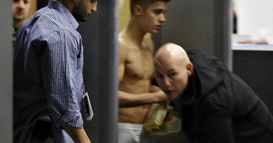 25.mar.2013 - Seguranças tentam bloquear a visão do cantor Justin Bieber enquanto ele atravessa o aeroporto Wladyslaw Reymont em Lodz, na região central da Polônia, após show